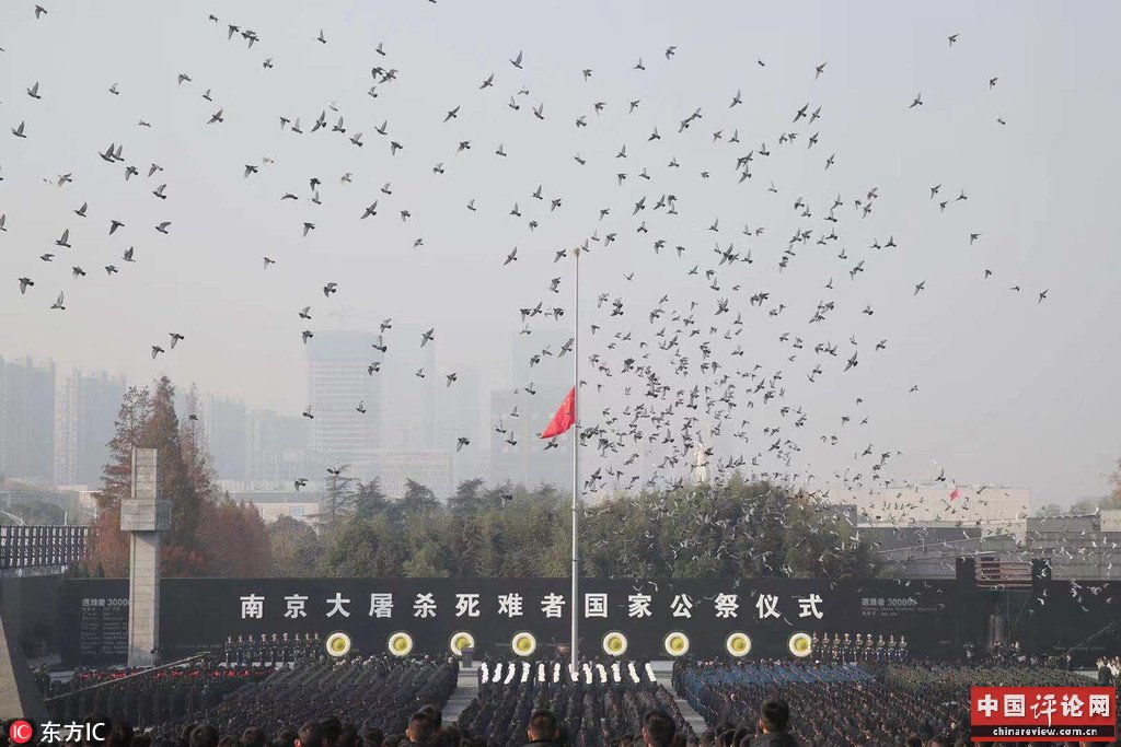 12月13日，公祭仪式现场降半旗放飞和平鸽。